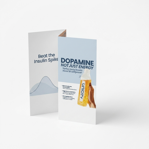 A folded printed brochure or flyer stands open on a light gray studio background. The front panel is mostly white with a large light blue rectangle, bold dark blue text reading 'DOPAMINE NOT JUST ENERGY,' a photo of a woman, and an illustration of a yellow bottle.